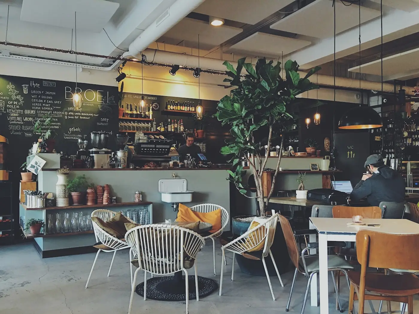Interior de una cafetería con mesas y barra